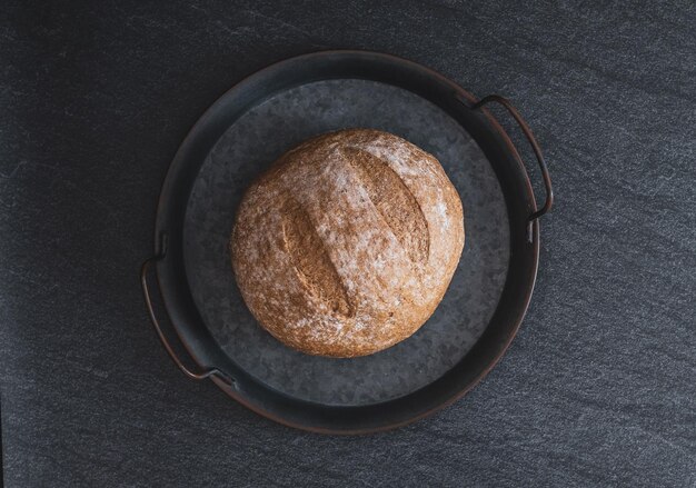 Un pane tondo di segale su sfondo nero