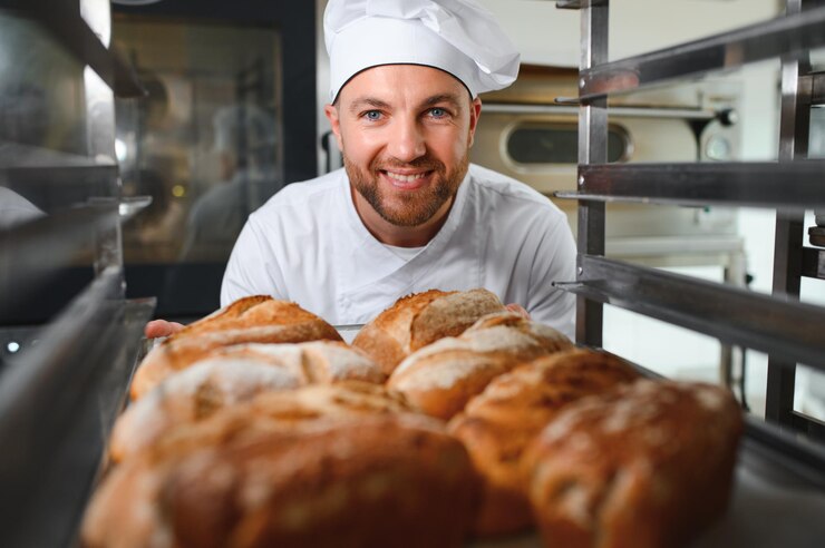 Foto un panettiere maschio con un assortimento di pane fresco in negozio