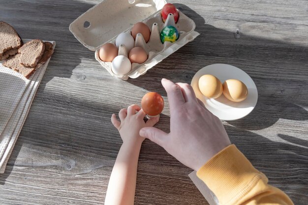 Un papà festeggia la Pasqua con il figlio piccolo Sbattono le uova mangiano le uova e fanno colazione Papà insegna al bambino