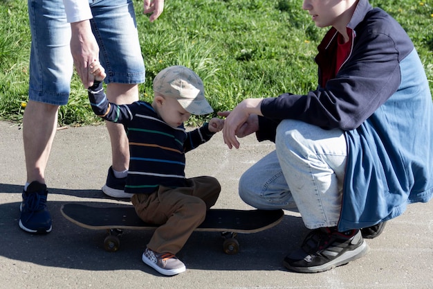 Un papà insegna al suo giovane figlio a fare skateboard con il figlio maggiore per tre anni