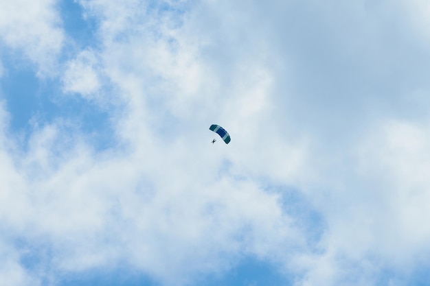 Un paracadutista in un cielo blu sotto le nuvole