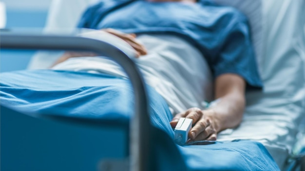 Un paziente giace su un letto in un letto d'ospedale.