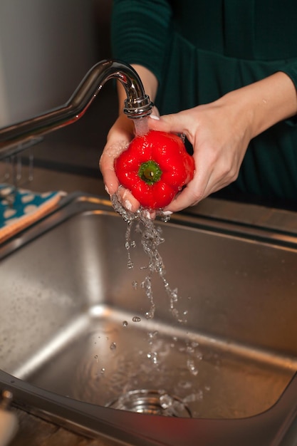 Un peperone è sotto l'acqua corrente