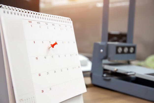 Un perno di colore rosso sul calendario, concetto per il pianificatore di eventi.