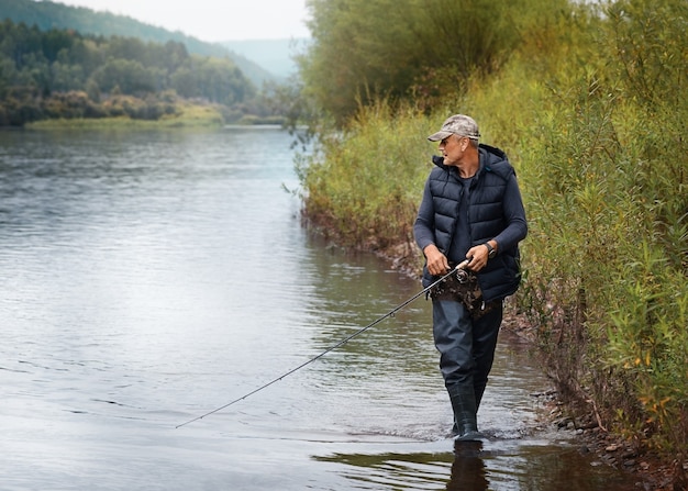 Un pescatore con una canna da pesca cattura un pesce