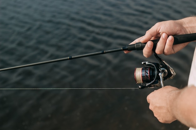 un pescatore con una canna da pesca sulla riva del fiume