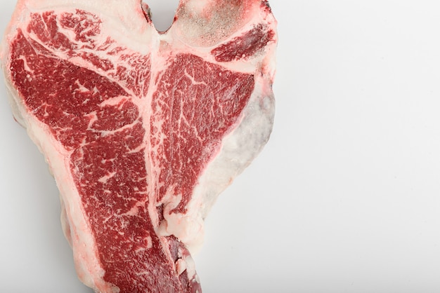 Un pezzo di carne di fattoria fresca t-bon su un bianco