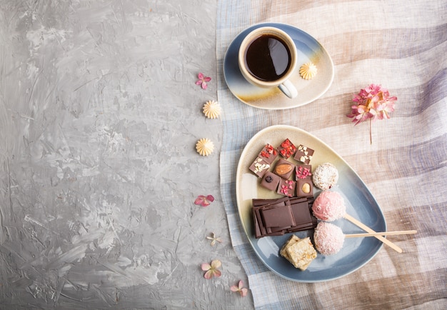 Un pezzo di cioccolato fatto in casa con caramelle al cocco e una tazza di caffè. vista dall'alto