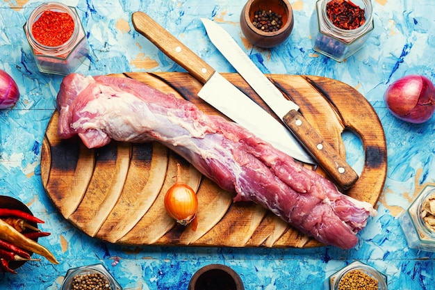 Un pezzo di filetto di maiale crudo fresco e ingredienti speziati