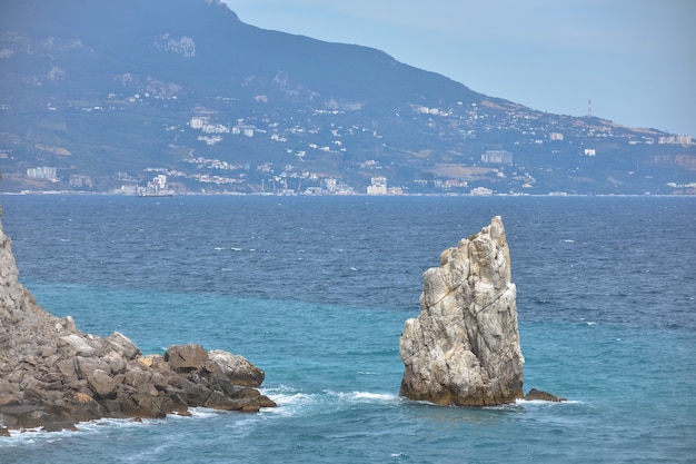 Un pezzo di roccia vicino al mare vicino alla costa, una vista delle rocce costiere vicino al castello Nido di rondine in Crimea, un grande pezzo di roccia distaccato al centro, costa a sinistra, vista mare