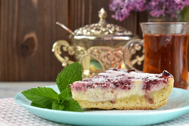 Un pezzo di torta con foglie di menta su un piatto blu