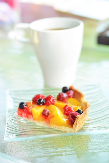 Un pezzo di torta con pesche e frutti di bosco