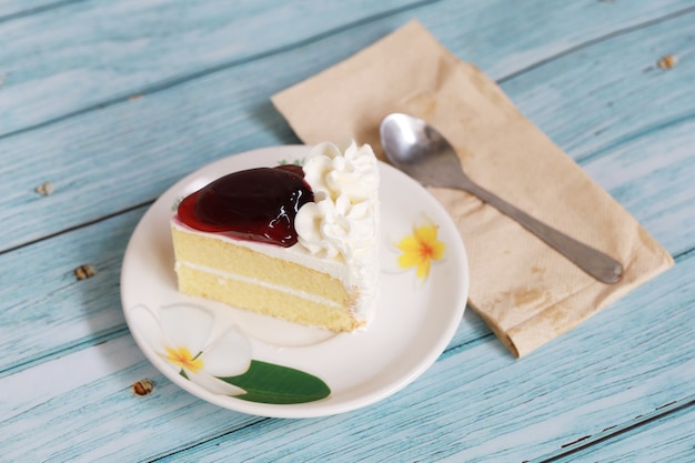 Un pezzo di torta di crema di mirtilli sul piatto bianco e mettere sul tavolo blu