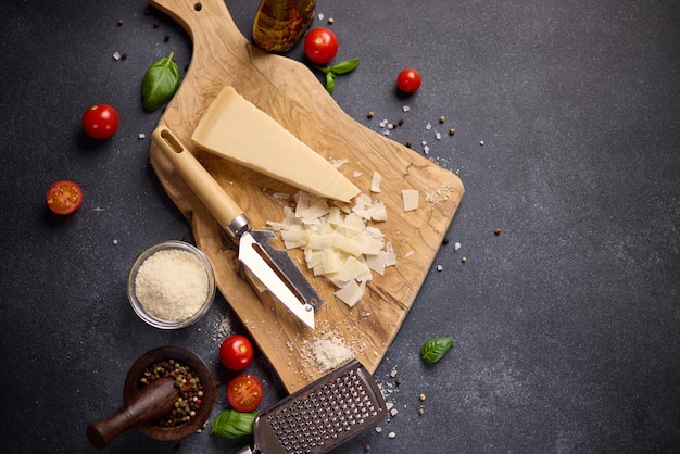 Un pezzo di tradizionale formaggio duro parmigiano italiano su una tavola da taglio in legno nella cucina domestica