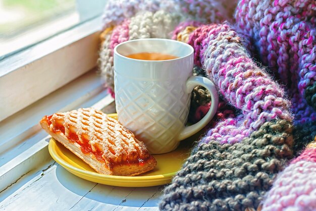 Un piano di tè caldo sullo sfondo di una coperta lavorata a maglia