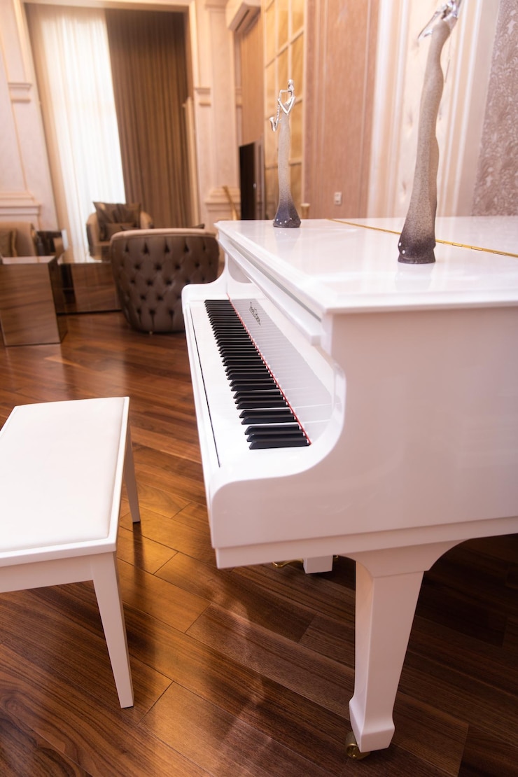 Foto un pianoforte bianco con accanto un tavolo bianco