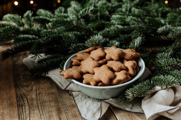 Un piatto con i biscotti su uno sfondo di rami di abete.