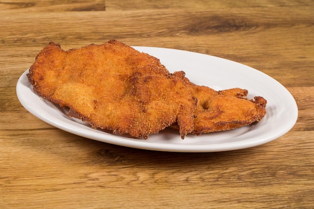 Un piatto con scaloppina spagnola di pollo alla milanesa filetti di pollo impanati