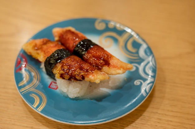 Un piatto con sopra un piatto blu con su scritto "sushi".