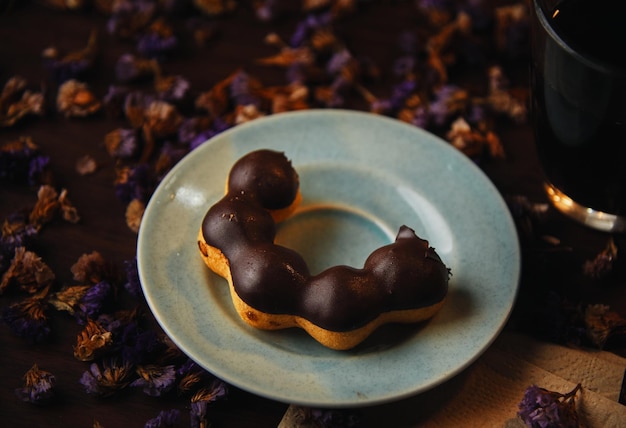 Un piatto con sopra una ciambella con sopra della glassa al cioccolato.