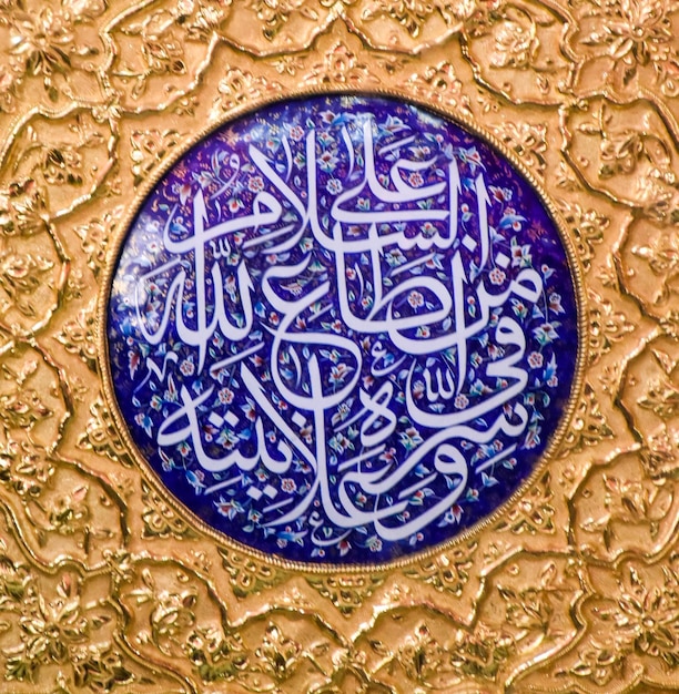 Un piatto d'oro con calligrafia araba che dice "calligrafia".