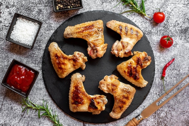 Un piatto di ali di pollo con coltello e forchetta su un tavolo.