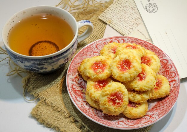 Un piatto di biscotti con una tazza di tè su un tavolo accanto.