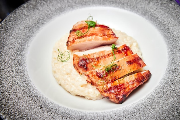 Un piatto di bistecca di pollo con risotto al formaggio