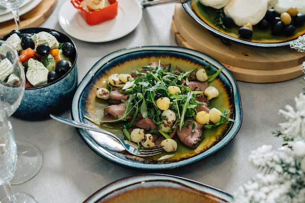 Un piatto di carne e patate al forno decorato con insalata Clouseup a tavola ben servito