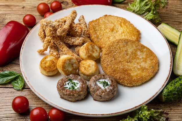 Un piatto di carne fritta con pollo fritto e patate fritte