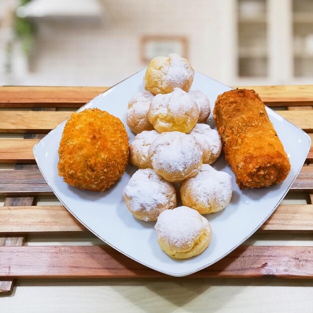 Un piatto di cibo con pasticcini sopra e qualche altro pasticcino sopra.