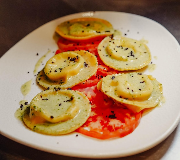 Un piatto di cibo con sopra pomodori e pepe nero