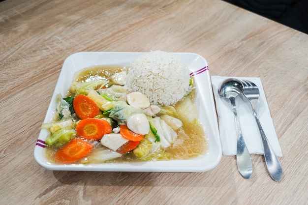 Un piatto di cibo con sopra riso e verdure