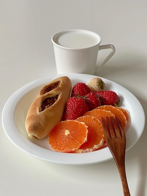 Un piatto di cibo con sopra una forchetta e una tazza di caffè sul tavolo.