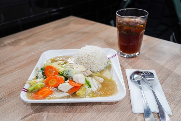 Un piatto di cibo con un bicchiere di coca cola sul lato.