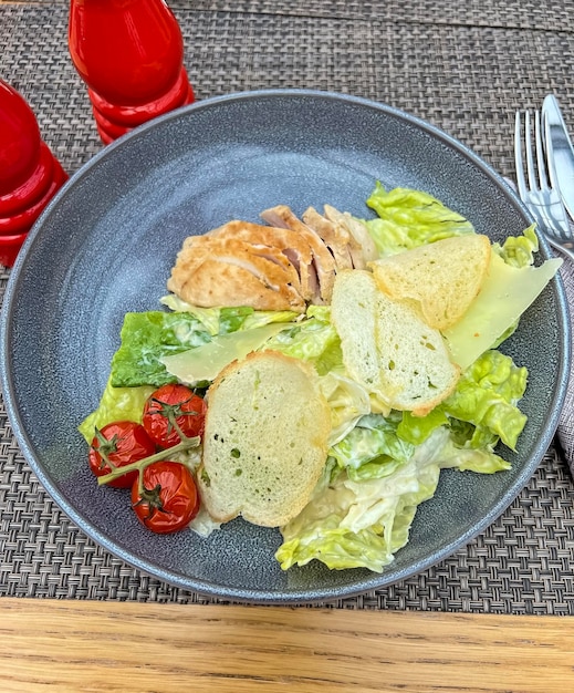 Un piatto di cibo con un'insalata e una forchetta e un coltello.