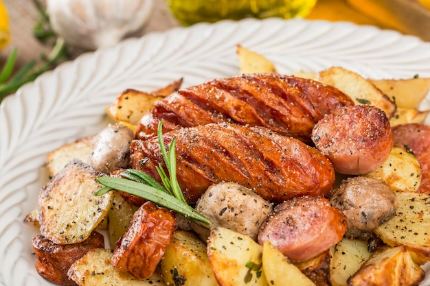 Un piatto di deliziose patate e salsiccia al forno