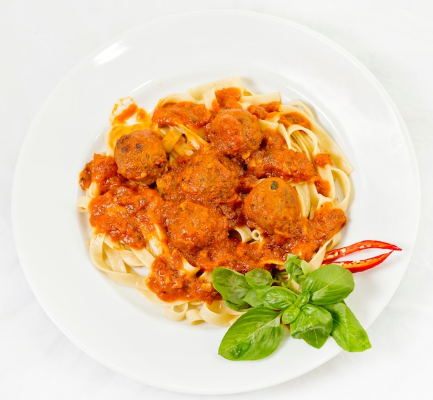 Un piatto di fettuccine e polpette di pasta con salsa di pomodoro