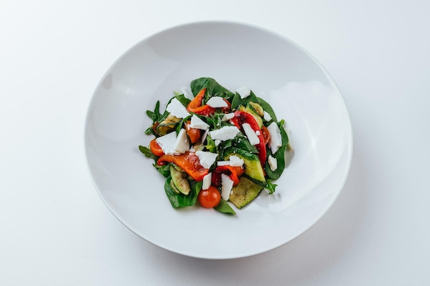 Un piatto di insalata con salsa rossa e cetriolo in cima.