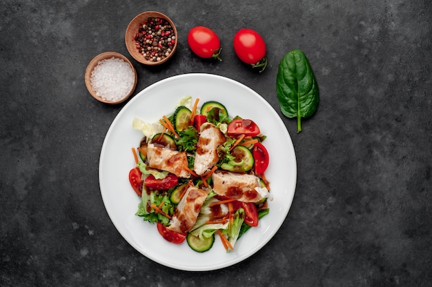 un piatto di insalata di pomodoro, pollo, cetriolo, carote, salsa di soia in un piatto