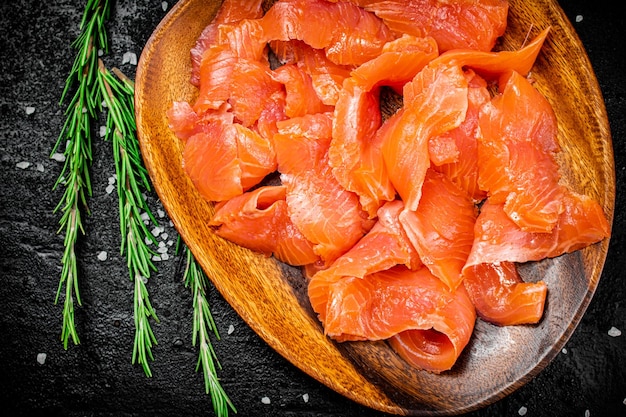 Un piatto di legno con fette di salmone salato