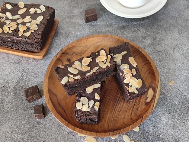 Un piatto di legno con sopra una fetta di torta al cioccolato e una tazza di caffè a lato.