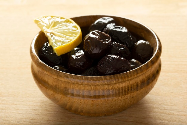 Un piatto di olive e una fetta di limone