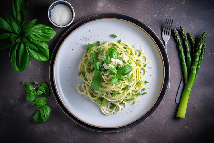 Foto un piatto di pasta con cipolle verdi e una forchetta su un tavolo accanto a coltello e forchetta.