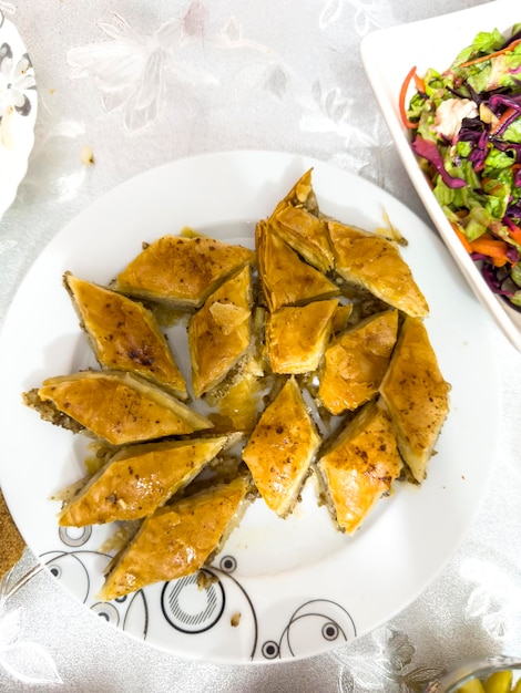 Un piatto di pasta turca con un'insalata sullo sfondo