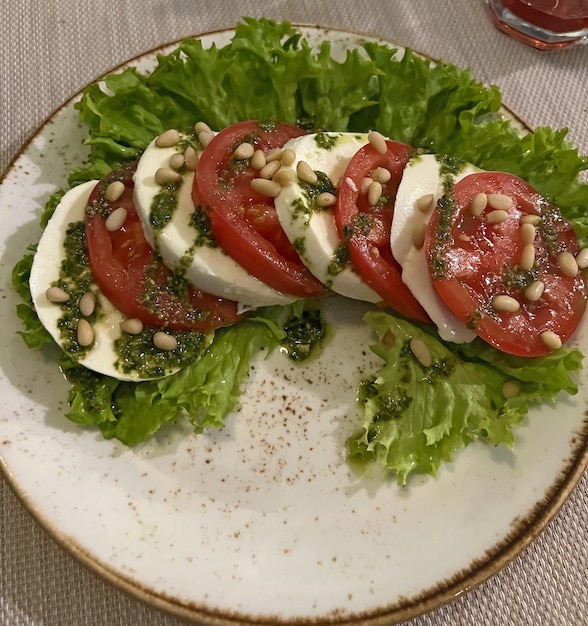 Un piatto di pomodori tagliati e lattuga con una fetta di cetriolo.