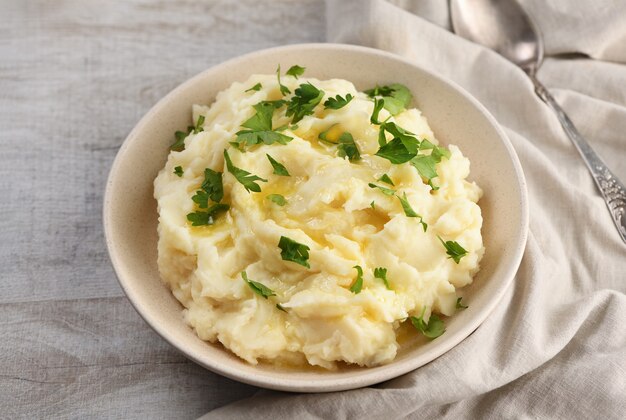 Un piatto di purè di patate versato con burro fuso e condito con verdure