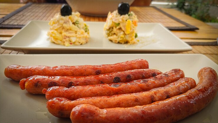Foto un piatto di salsicce con contorno di insalata di patate