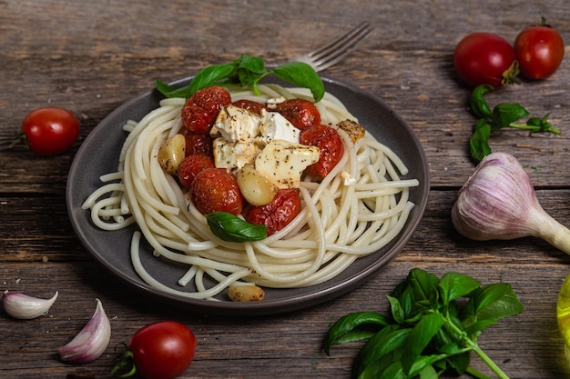 Un piatto di spaghetti con feta e feta sopra