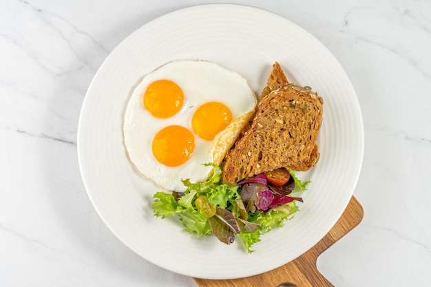 Un piatto di uova, pane e insalata